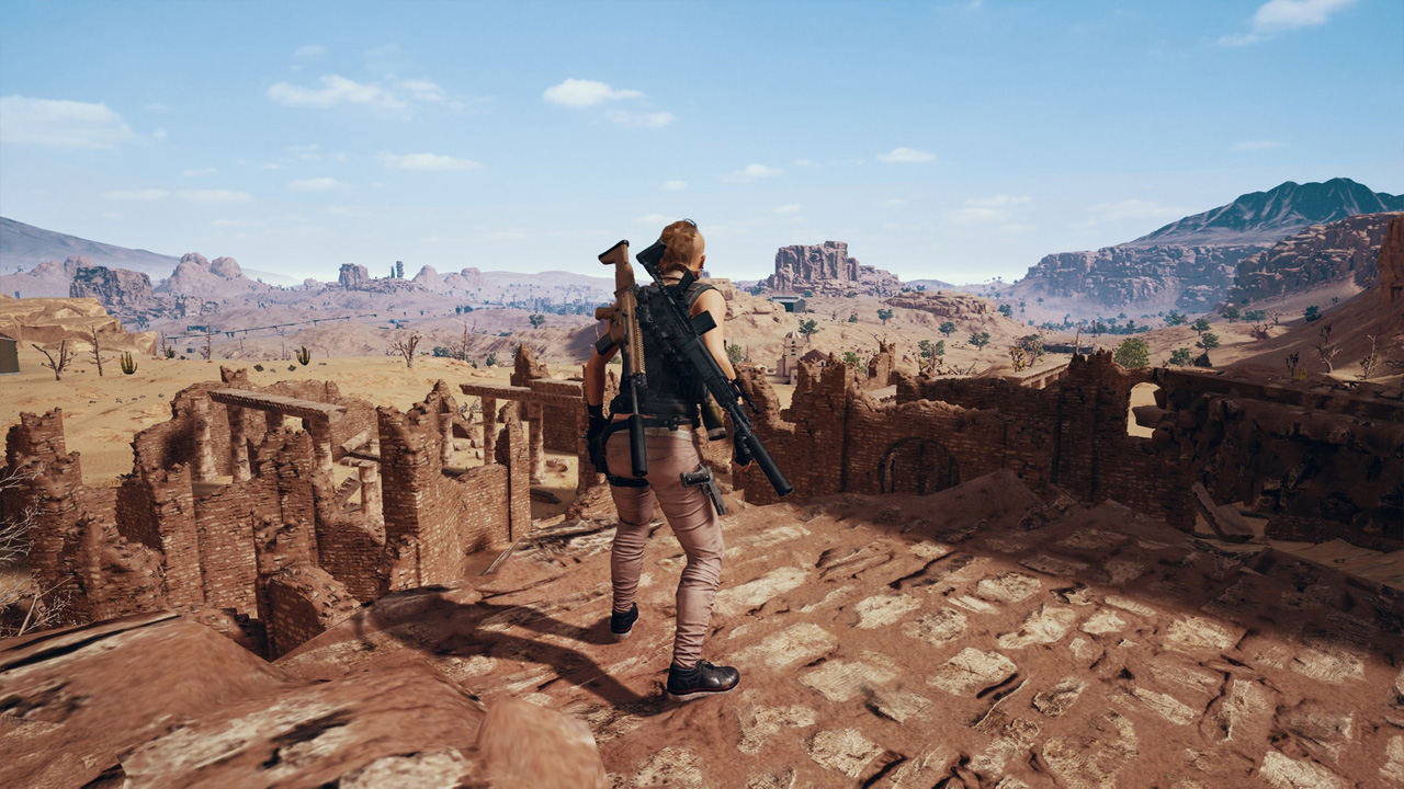 Personagem armado de PUBG na parte alta de ruínas, observando o cenário desértico