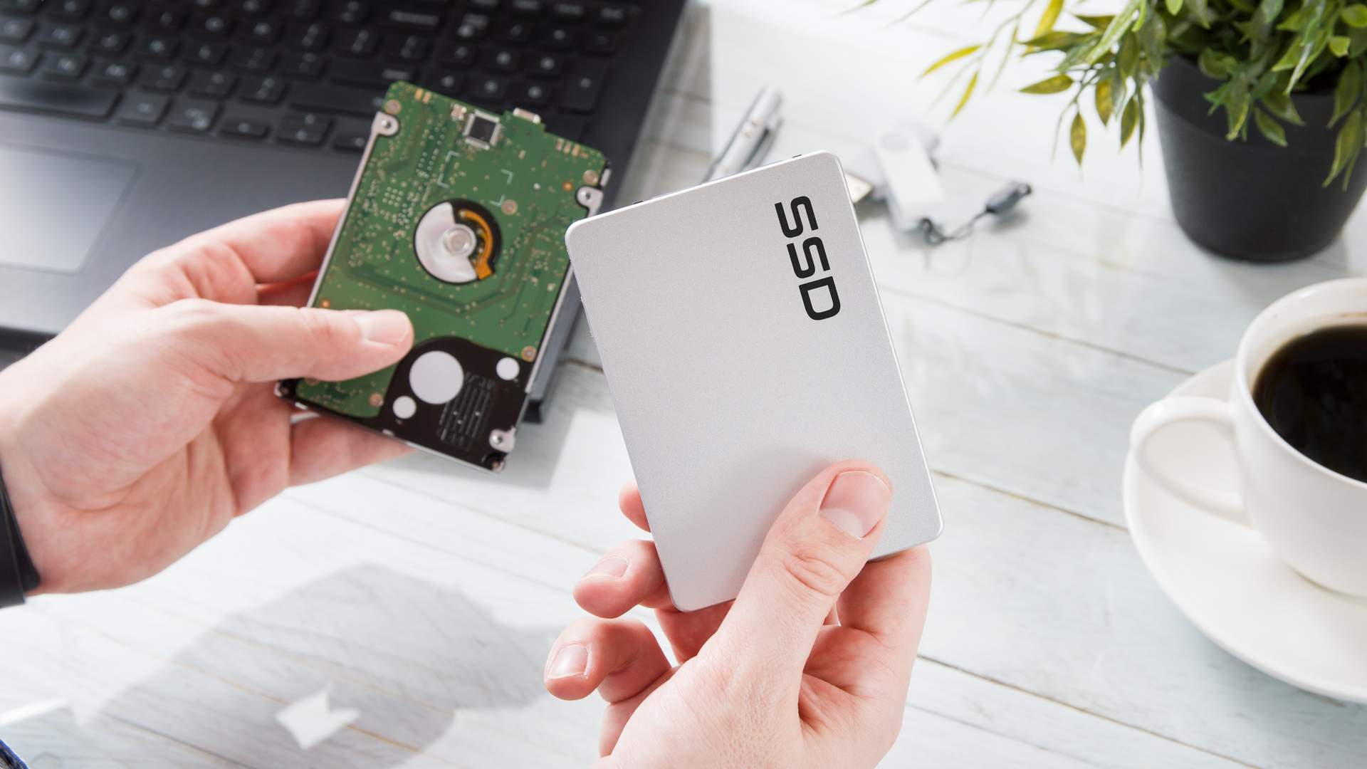 Mãos segurando um SSD e um HD em cada