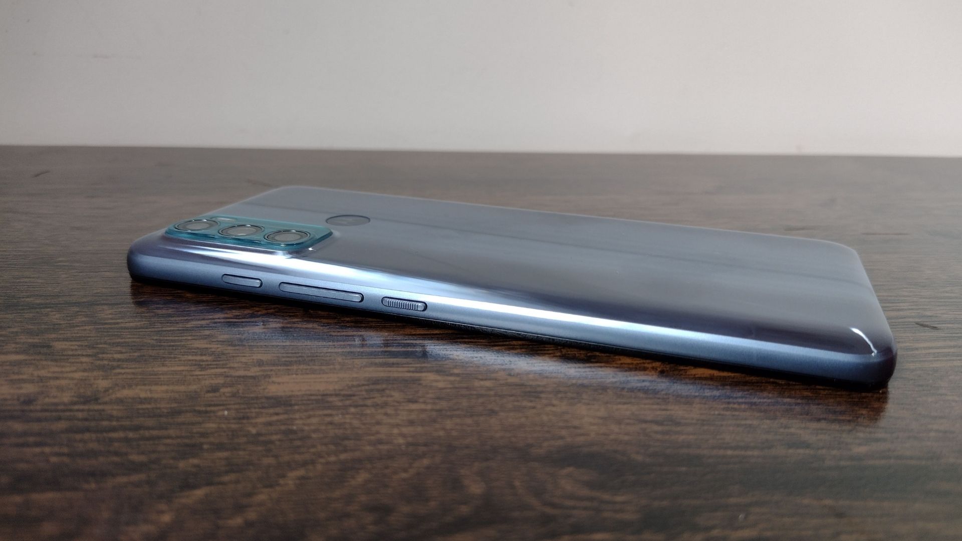 Moto G60 em cima de uma mesa de madeira, com parte traseira voltada para cima