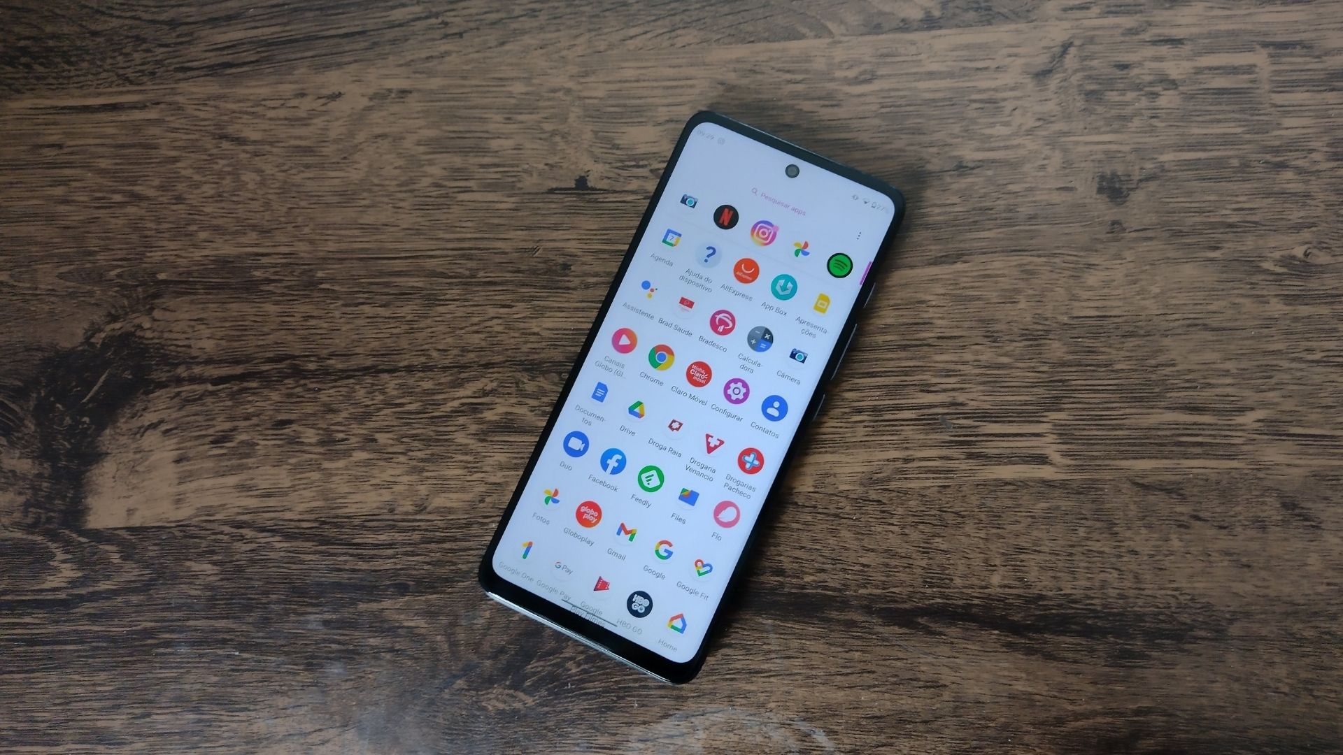 Moto G60 em cima de uma mesa de madeira, com parte frontal voltada para cima